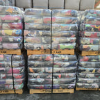 Stacks of bundled rags on pallets with 'Stone Rags' branding.