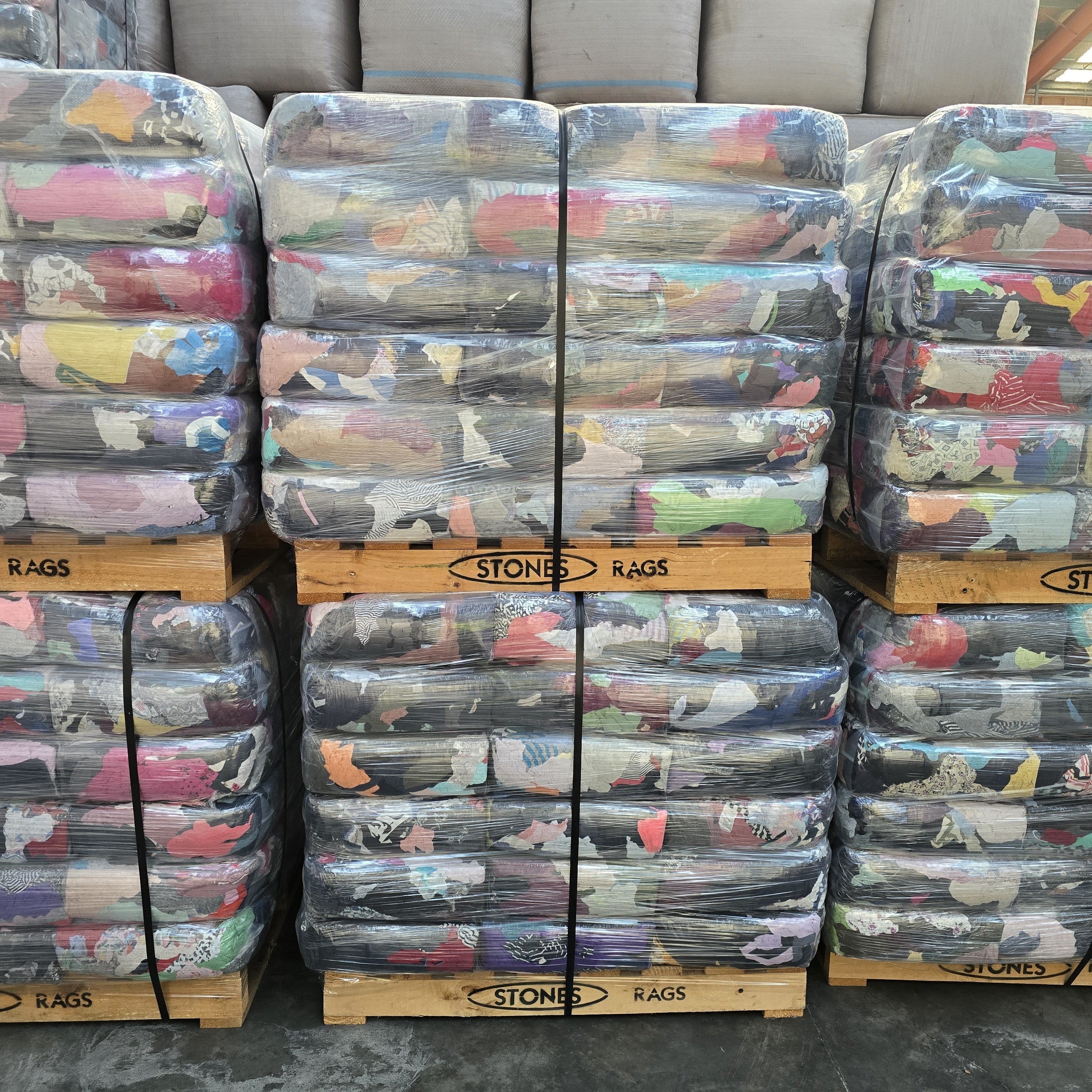 Stacks of bundled rags on pallets with 'Stone Rags' branding.